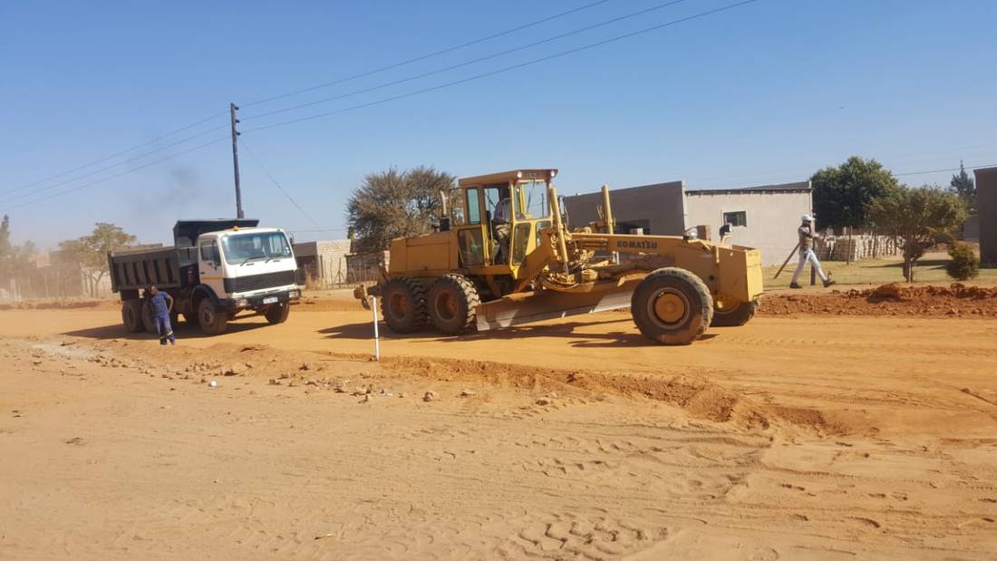 Grader and tipper working the layerworks