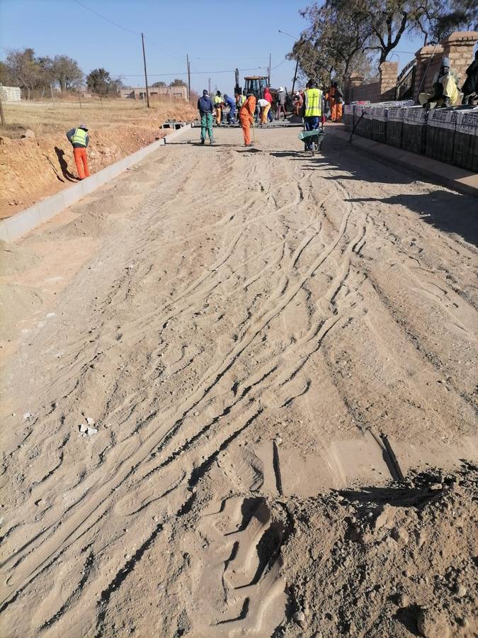 Paving gang laying blocks on bedding sand